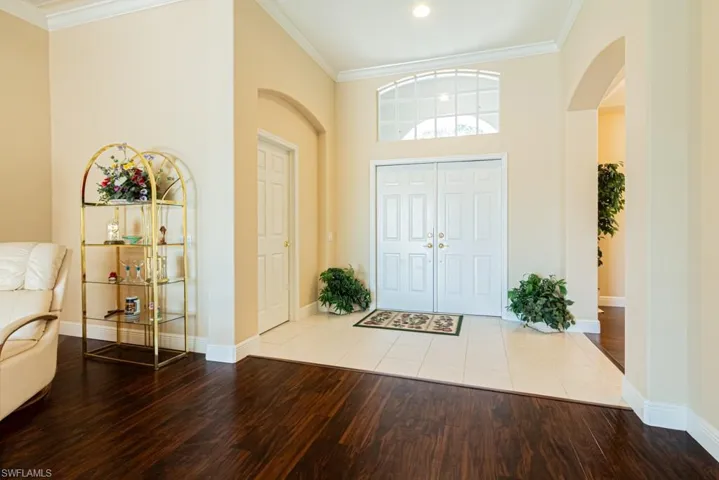 Tiled foyer with a high ceiling and ornamental molding