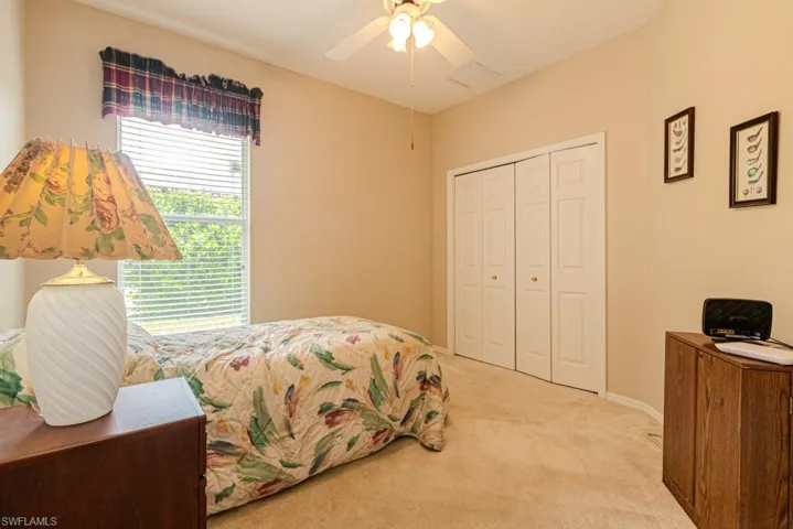 Bedroom with a closet, ceiling fan, and carpet floors