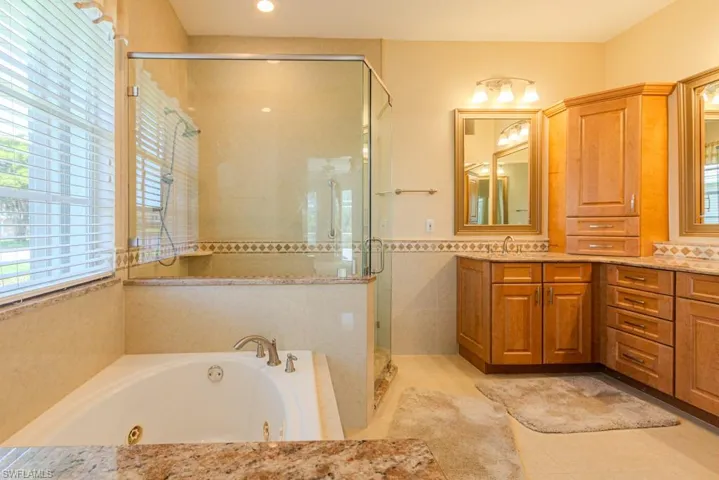 Bathroom featuring tile flooring, vanity, and independent shower and bath