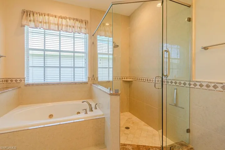 Bathroom featuring a wealth of natural light and separate shower and tub