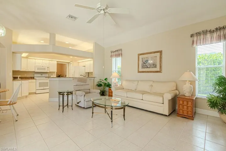 Tiled living room featuring a wealth of natural light and ceiling fan