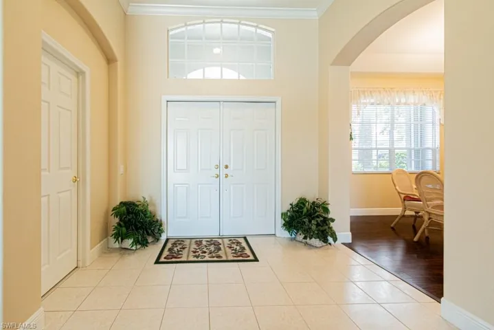 Foyer with ornamental molding and light wood-type flooring