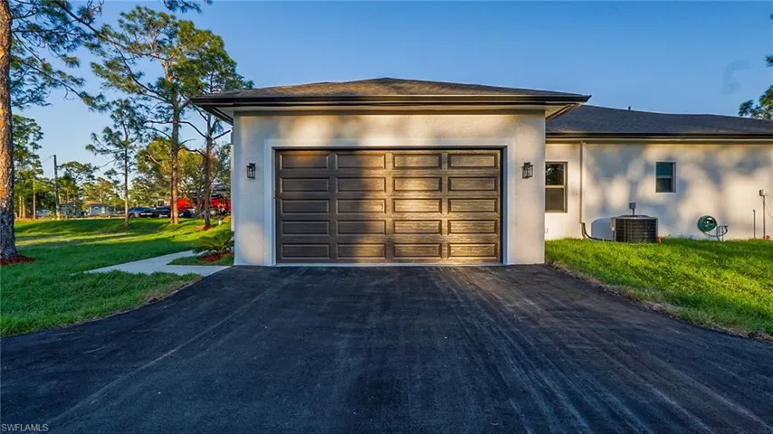 Garage featuring aphalt driveway and cooling unit