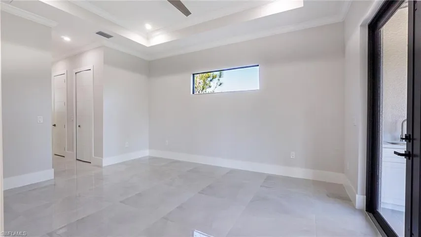 Unfurnished room featuring recessed lighting, a raised ceiling, visible vents, ornamental molding, and baseboards