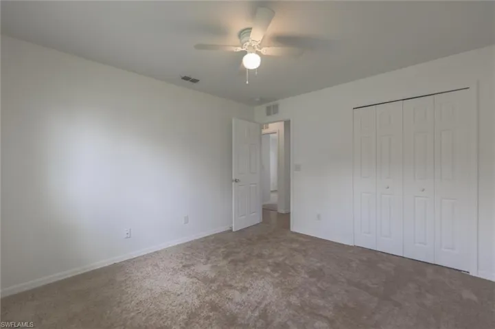 Unfurnished bedroom featuring carpet floors, ceiling fan, and a closet