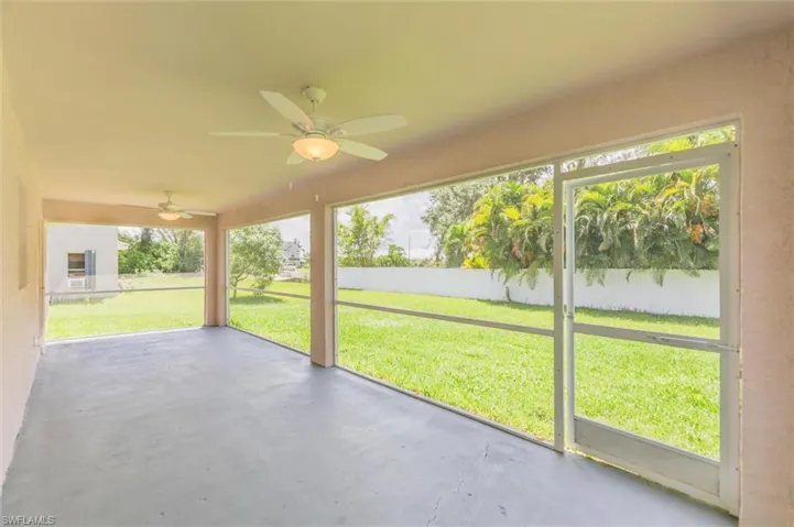 Unfurnished sunroom with plenty of natural light and ceiling fan