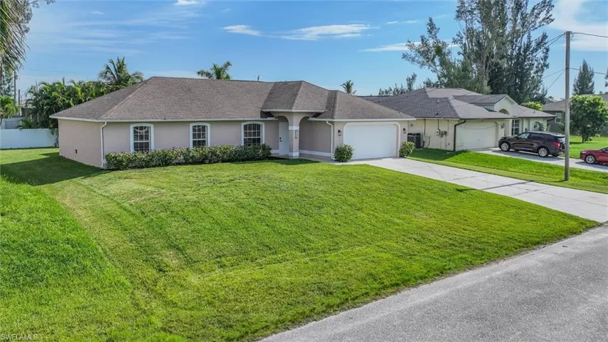 Ranch-style house featuring a front lawn and a garage