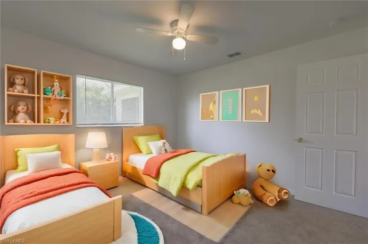 Carpeted bedroom featuring ceiling fan