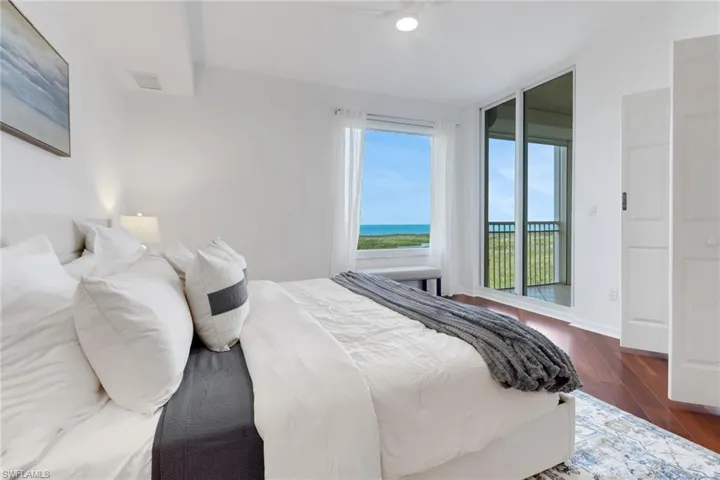 Bedroom with wood flooring and access to outside lanai overlooking the gulf