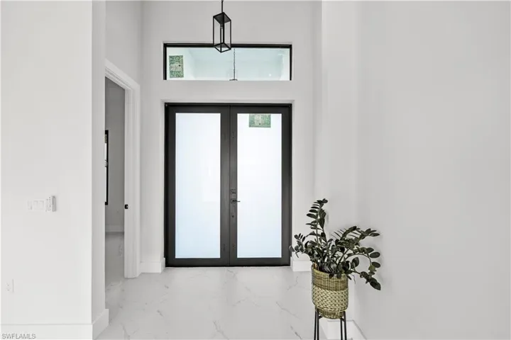 Swimming pool featuring a sunroom, a patio, a residential view, and glass enclosure