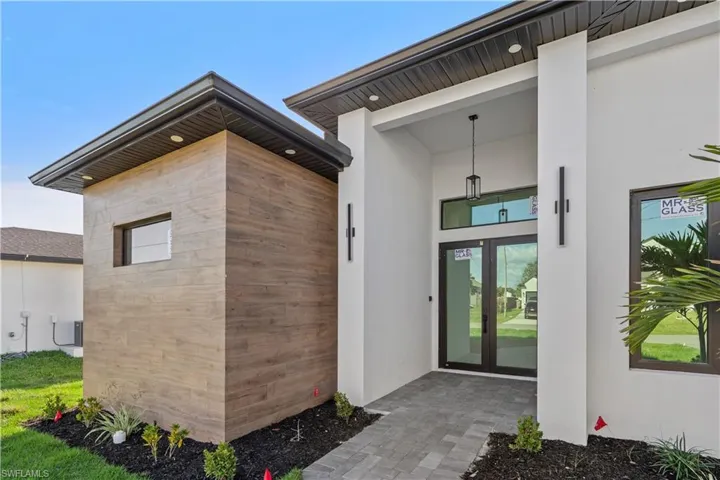 Doorway to property featuring french doors and stucco siding