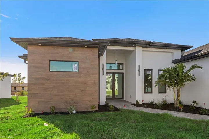 View of front facade featuring french doors, a front lawn, and stucco siding