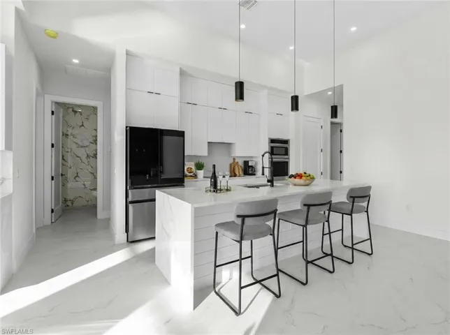 Dining space with a sunroom, a tray ceiling, and suspended lighting
