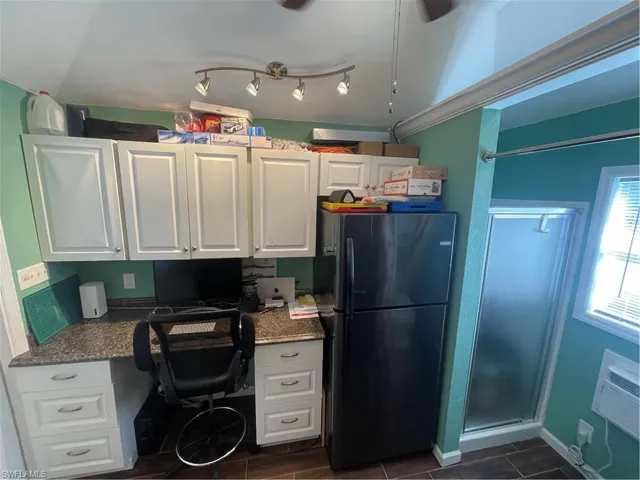 Home office featuring built in desk and baseboards