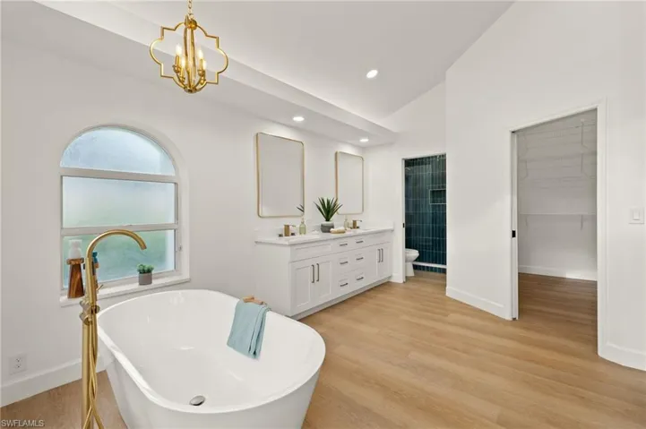 Over the Tub is a New Gold Chandelier, Gold Faucet with Spillover, all Gold Accents throughout the space.