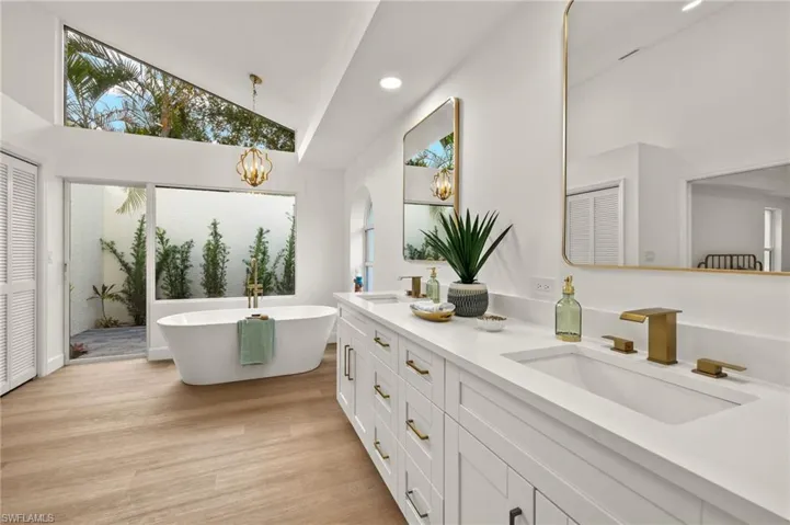 The Custom oversized Windows bring the outside into the this Spa Level Primary bathroom with Free Standing Tub