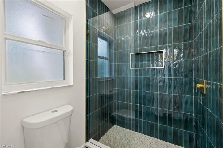 The Green Vertically Installed Subway Tile was the perfect choice for the Primary Shower with Frameless Glass