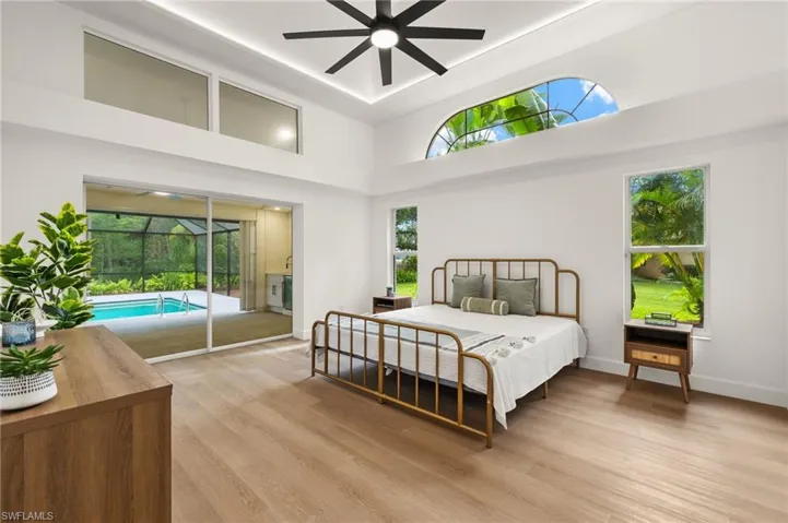 Primary Bedroom has oversized Windows, a Pocket Slider, a Tray Ceiling with LED Accent Lighting