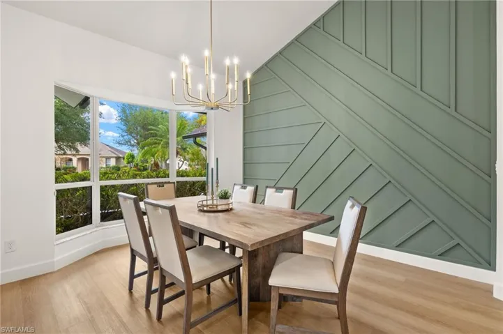 Dining Room has a Custom Built Wood Feature Wall with a New Gold Chandelier and oversized Windows