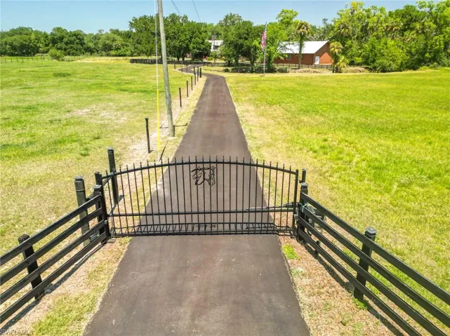 View of gate featuring fence and a lawn