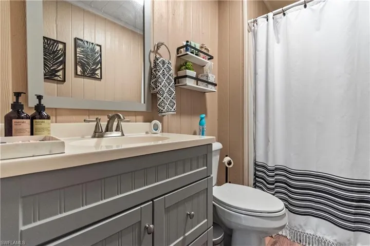 Full bath featuring toilet, a shower with curtain, and vanity