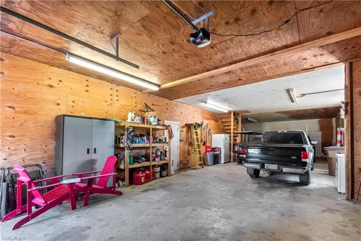 Garage with a garage door opener and freestanding refrigerator