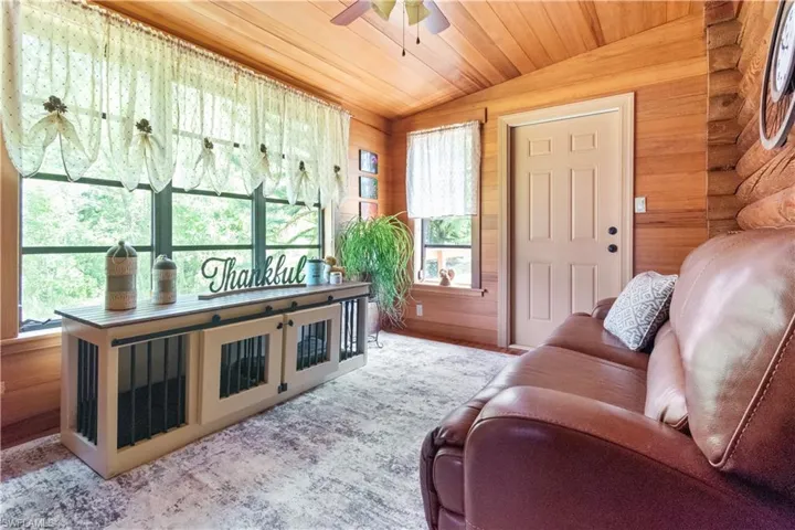 Living area featuring vaulted ceiling, wooden ceiling, and ceiling fan