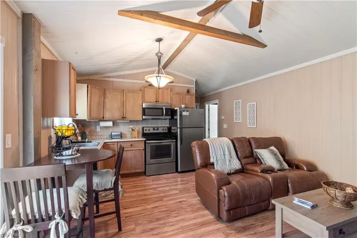 Kitchen featuring stainless steel appliances, a sink, light wood-type flooring, decorative backsplash, and open floor plan