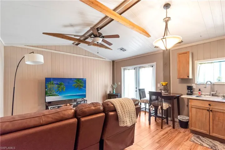 Living room with light wood-style flooring, visible vents, lofted ceiling, and a wealth of natural light