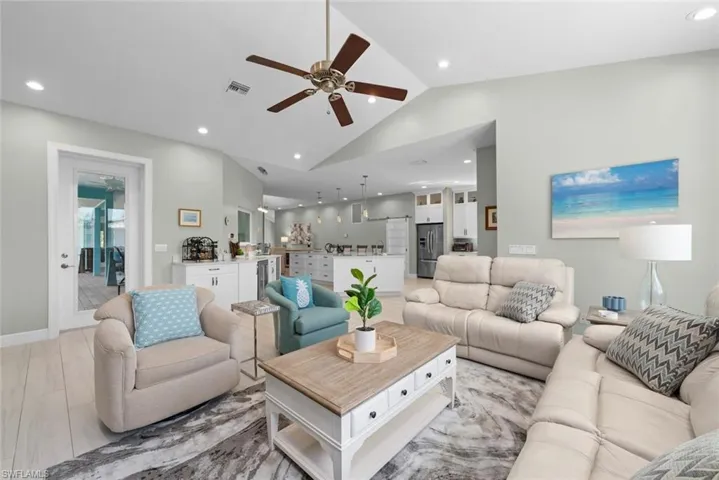 Living room featuring vaulted ceiling, ceiling fan, and recessed lighting