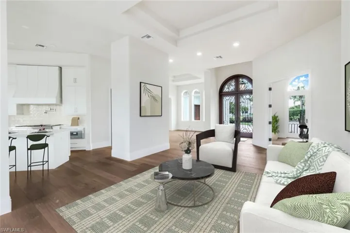 VIRTUALLY STAGED & FURNISHED Living room facing front door and formal dining area. Kitchen to left.