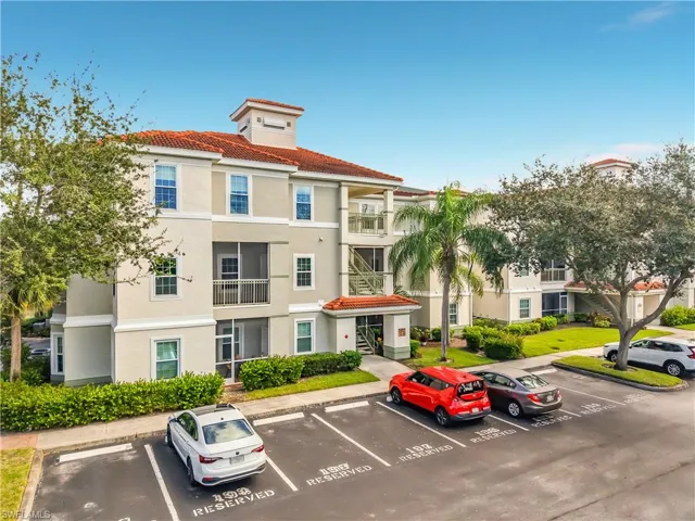 Multi-story stucco exterior featuring clay tile roofing and screened balconies