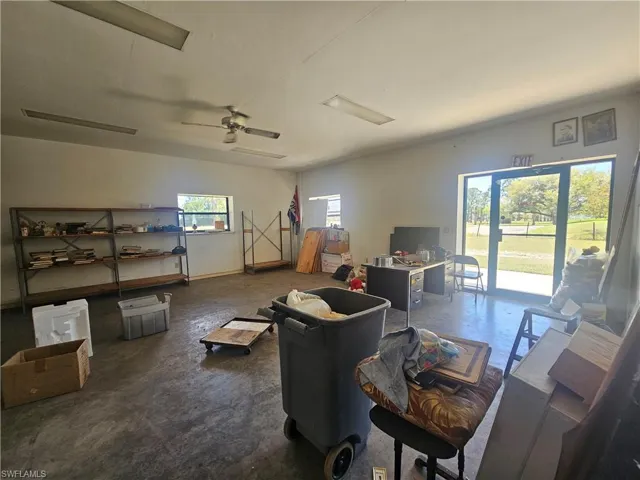 Living area featuring ceiling fan and concrete floors
