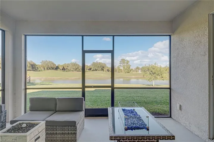 Sunroom / solarium with a water view, an outdoor living space with a fire pit, and healthy amount of natural light