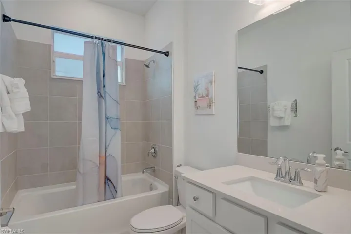 Full bath featuring shower / tub combo with curtain and vanity