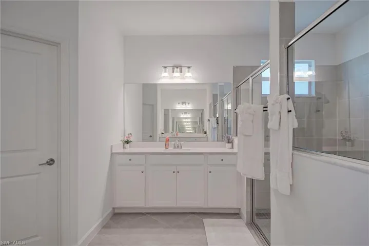 Bathroom featuring vanity, a shower stall, and light tile patterned flooring