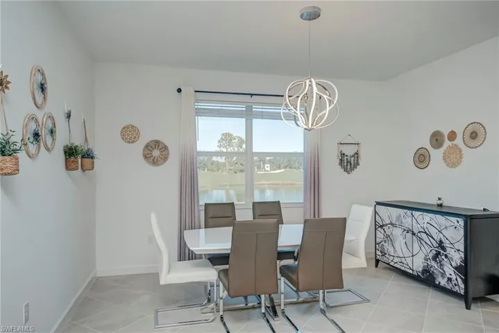 Dining area with a water view, a chandelier, and light tile patterned floors