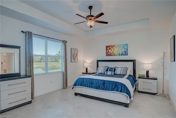 Bedroom featuring a raised ceiling and a ceiling fan