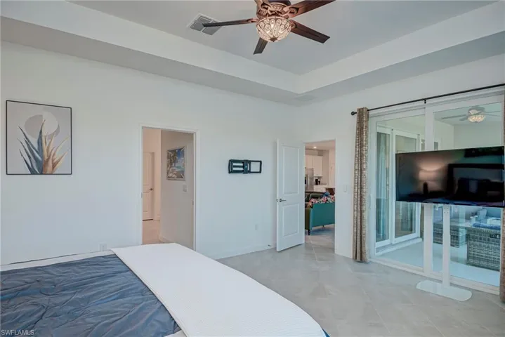 Bedroom with a ceiling fan and a tray ceiling