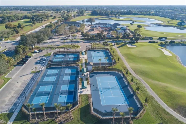 Aerial view of property and surrounding area with a local golf course and a nearby body of water