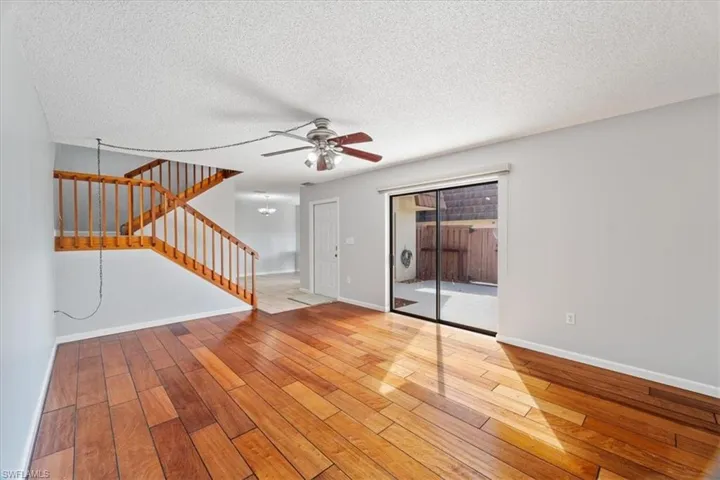 Empty room with ceiling fan, a textured ceiling, and light hardwood / wood-style flooring