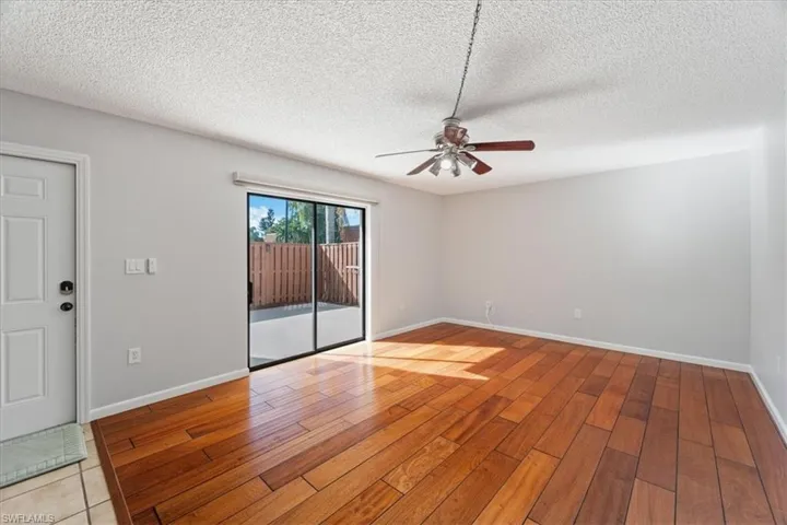 Unfurnished room featuring ceiling fan, light wood-type flooring, and a textured ceiling
