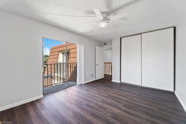 Unfurnished bedroom with access to outside, ceiling fan, a textured ceiling, dark hardwood / wood-style flooring, and a closet