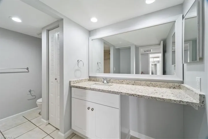 Bathroom with tile patterned flooring, vanity, and toilet