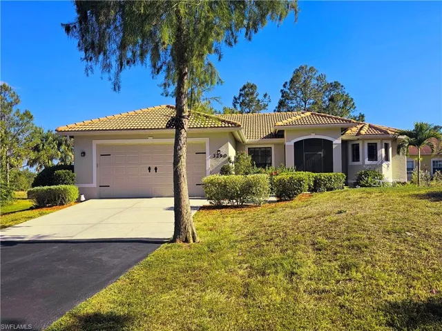 Mediterranean / spanish home with a tile roof, a garage, stucco siding, driveway, and a front lawn