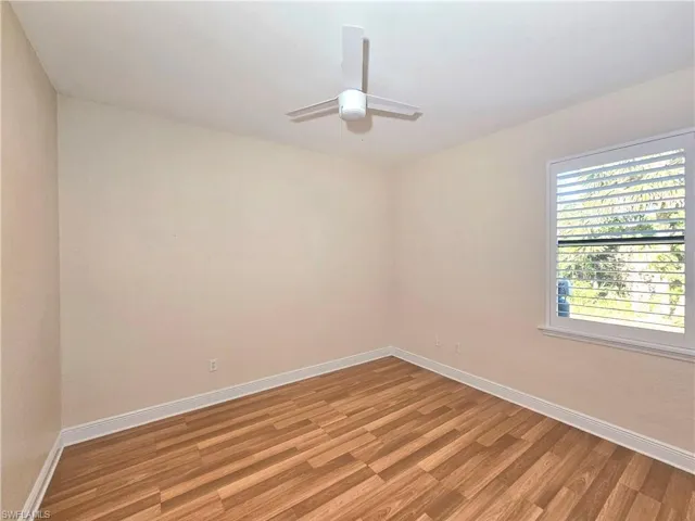 Spare room with light wood-type flooring, baseboards, and ceiling fan