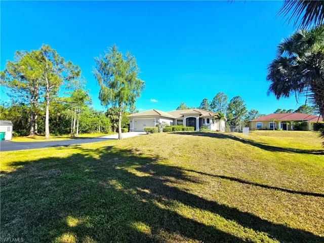 Ranch-style home with driveway, a front lawn, and an attached garage