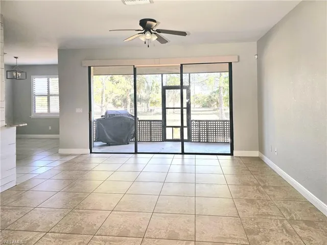 Empty room featuring a ceiling fan, baseboards, and light tile patterned floors