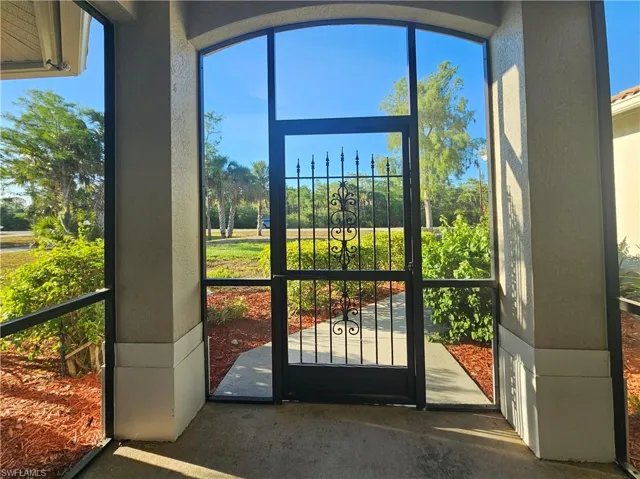 Doorway to outside featuring a textured wall and healthy amount of natural light