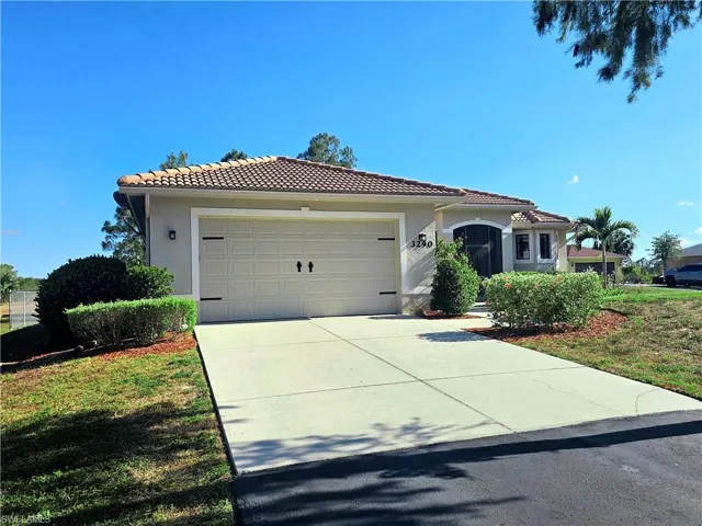 Mediterranean / spanish-style home with a tile roof, stucco siding, concrete driveway, and an attached garage